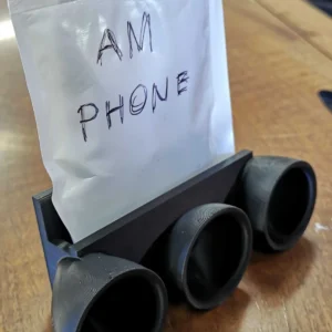 Klang · mobilholder med lydtragt. Kildeudgiverens foto af modellen Passive Speaker/Amplifier Phone Stand for Bottom-Speaker Phones; original farve. Foto: gexgecko.