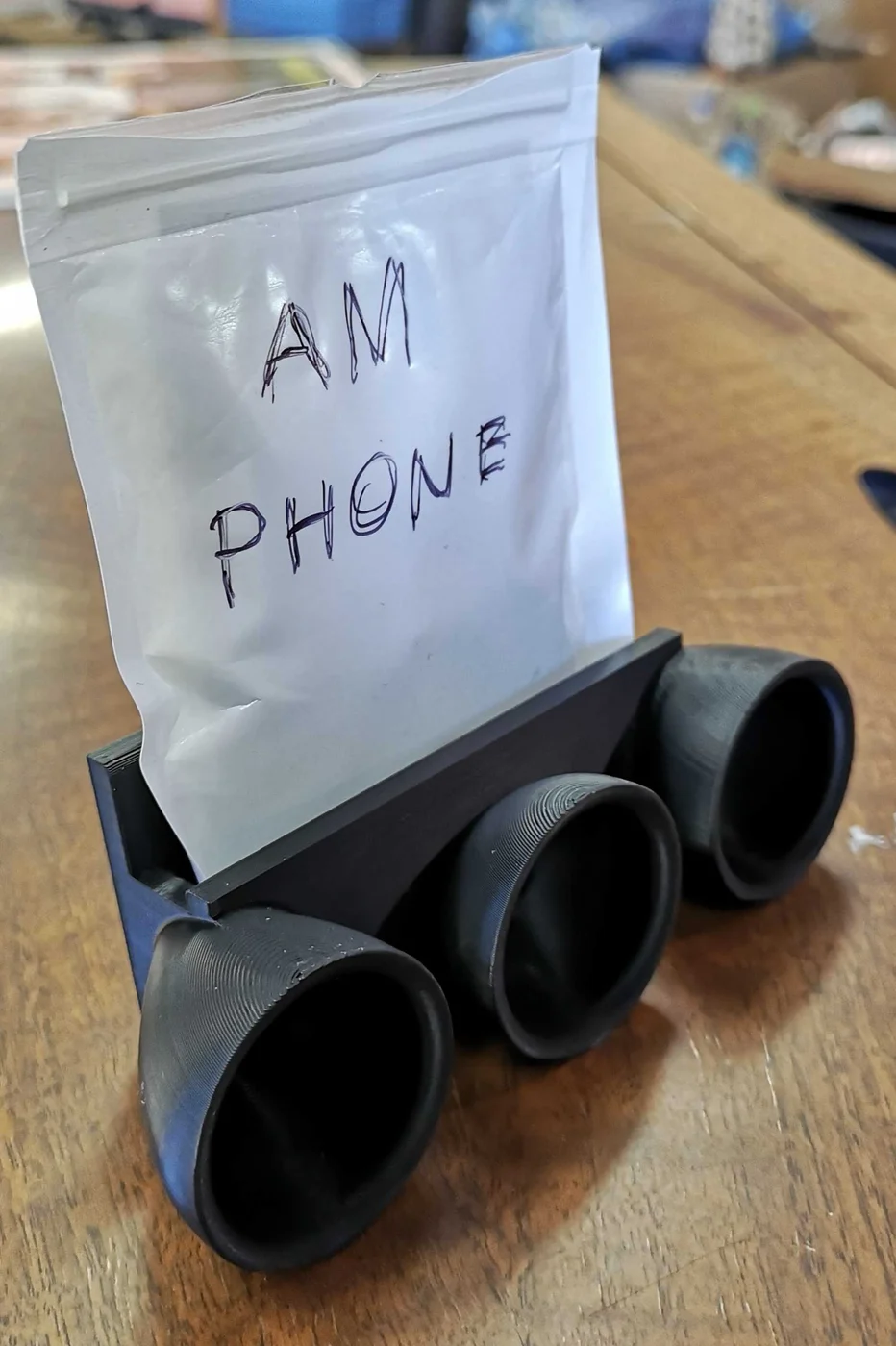 Klang · mobilholder med lydtragt. Kildeudgiverens foto af modellen Passive Speaker/Amplifier Phone Stand for Bottom-Speaker Phones; original farve. Foto: gexgecko.